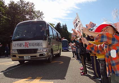 新潟県側の工事用ゲート前で下田地区の名下保育所と荒沢保育所の園児30人近くが歓迎