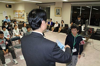 燕市の広報紙「広報つばめ」の「子ども版」を製作した子ども記者の終了式で、子ども記者に記念品を手渡す鈴木市長