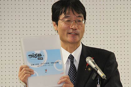 記念品のファイル「活動の記録」を紹介する鈴木市長
