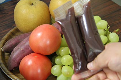 真空パックのジュースとその中に詰まった果物や野菜