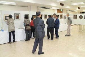 27日から燕市総合文化センターで開かれる燕市中央公民館文化祭に向けて26日夜、展示作業を行う彫金クラブ