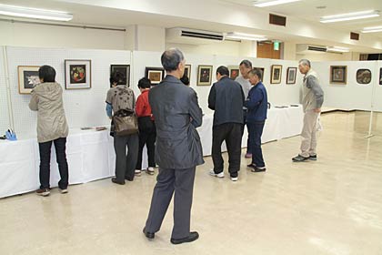 27日から燕市総合文化センターで開かれる燕市中央公民館文化祭に向けて26日夜、展示作業を行う彫金クラブ