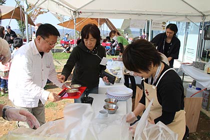 27、28日と行われているスノーピークの「雪峰祭2012秋」で初日27日の本社で豚汁とおにぎりをサービスするようす