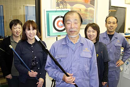 米山工業でスポーツ吹矢の「チーム米山」の社員と県央三条支部支部長の米山隆明さん(中央)