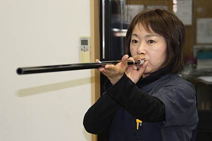 筒を的に向けて構えて矢を吹く