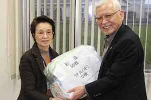 つばめ福祉会の岡田理事長(右)に寄贈するタオルを手渡す燕市シルバー人材センターの伊藤理事長(左)