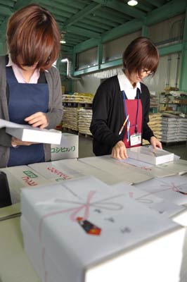 もちのパックにのし紙を張る作業