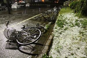 6日夜、燕三条駅の駐輪場に残された自転車はすべて風で倒され、植え込みにはあられやみぞれ白く残る