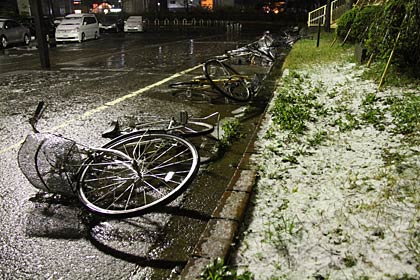 6日夜、燕三条駅の駐輪場に残された自転車はすべて風で倒され、植え込みにはあられやみぞれ白く残る
