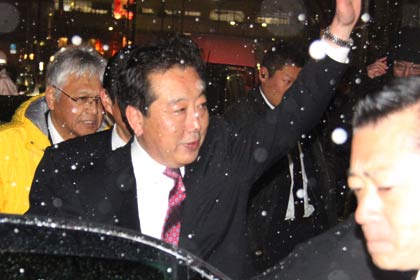 再び強く降り始めた雪のなか手を降って車に乗り込む野田首相
