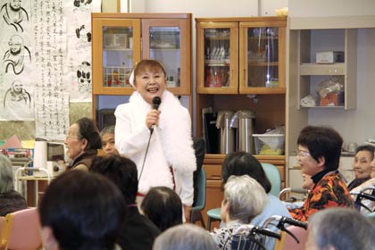 入居者の間に入って歌う川井美和さん