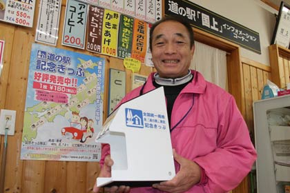  道の駅国上の「道の駅記念きっぷ」の販売を開始した「味処 花てまり」できっぷ販売用のディスプレーを手に
