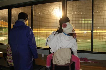 記者室からメッセージを見学する親子