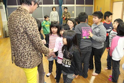 矢代さんに握手を求める児童クラブの子どもたち