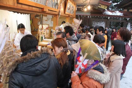 臨時に開設された御神札授与所で札やお守りを求める参拝客