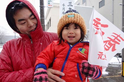 沿道で応援にする人に初めて配った「新春　三条市元旦マラソン大会」小旗、名古屋豊市議も親子で小旗を手に応援