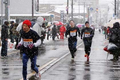 降りしきる雪のなかゴールへ向かう出場者
