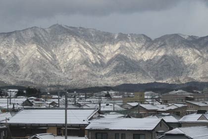  年末年始は大荒れだったが、新年のあいさつの間、議場から望む弥彦山は雲の切れからの日差しに照らされた
