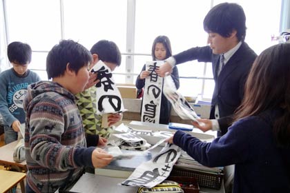 冬休みの宿題の書き初めを提出する児童