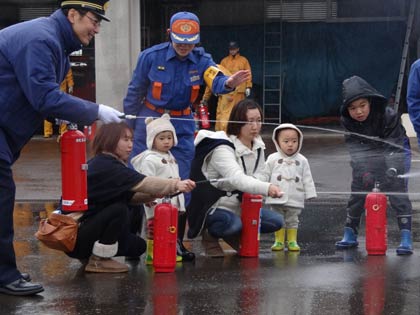水消火器の訓練に参加する市民