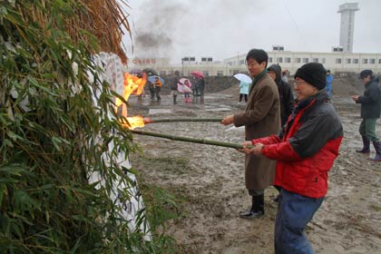  塞の神に点火、いちばん手前が荒木会長、その奥が鈴木市長