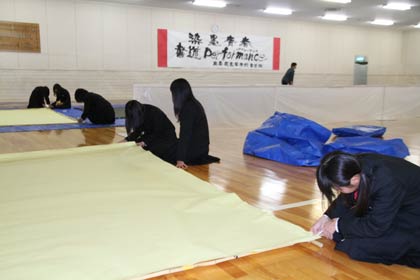 第9回三条市美術展の開場式イベントで書道パフォーマンスを行う県立三条東高書道部が会場で準備作業