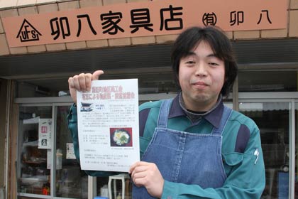 27日にふれあいパーク久賀美で「海の恵みアサリとあごの出汁雑煮」を振る舞うちらしを手に諏訪町兄貴会会長の山田さん