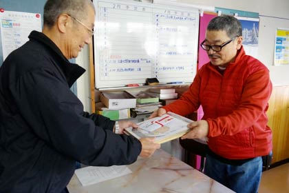 五十嵐川漁協事務所で山井代表組合長(左)に善意を手渡す龍昇園の刈屋さん