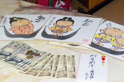 刈屋さんが寄付したチャリティーラーメンの売り上げと荘眠月さん作の色紙
