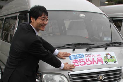 「おでかけ きららん号」のマグネットシートを張る鈴木市長