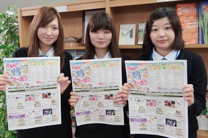 「三もんの得2クーポン」を手に利用をPRする三条商工会議所職員