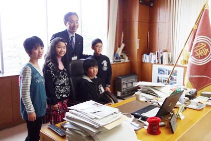 市長のいすに座って記念写真