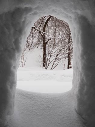 かまくらから外の雪景色を見る