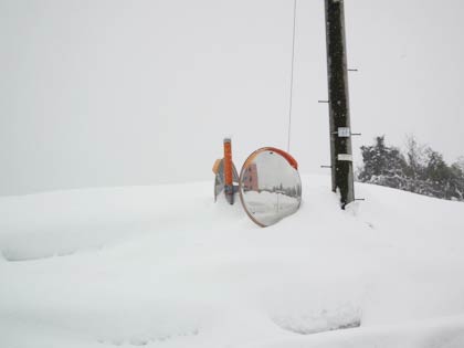 カーブミラーの支柱はすっぽり雪に埋まっている
