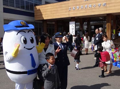 三条市立月岡小学校の玄関前で春の交通安全運動出発式と新一年生交通安全キャンペーン