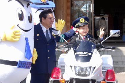 白バイにまたがって小林署長とひかるくん、ひかりちゃんと記念撮影する新一年生