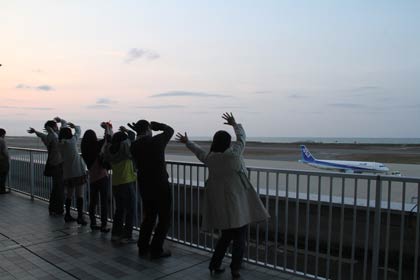新潟空港で帰郷する池田君に手を振って見送る三条の仲間たち