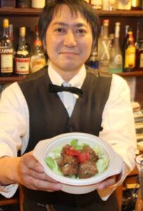 分水おいらん道中の「つばめるしぇ」で「noanoa」が出店、販売する「とりにくのレモン和え丼」と店主の石橋さん