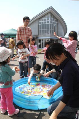 燕市交通公園のミニゲーム、スーパーボールすくい、その向こうはこどもの森の建物