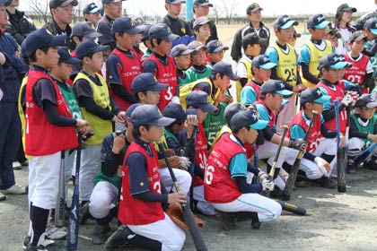 真剣な表情で指導を食い入る見詰める野球少年たち