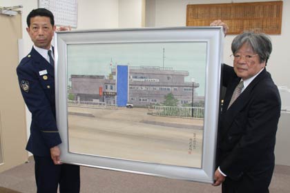 穂苅さん(右)が燕署の旧庁舎を描いた作品、左は中村署長