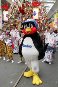 燕・戸隠神社の万灯を背につば九郎