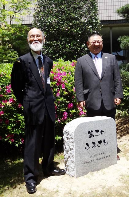 記念の石碑を前に発起人の佐竹紀さん(左)と医師の今野明さん