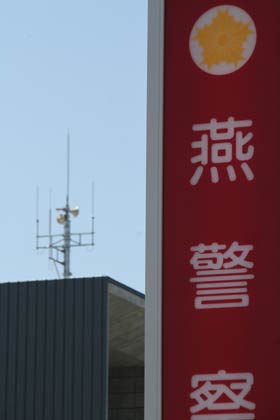  燕署の看板と左は燕市役所新庁舎に設置された防災無線のスピーカー