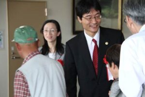25日開かれた鈴木市長の市政報告会の閉会後、参加者を見送る鈴木市長夫妻