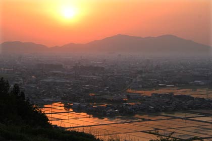  26日夕方、三条市・大崎山から弥彦山の陰に沈みゆく夕日を見る