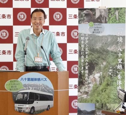 記者会見で「秘境八十里越体感バス」の利用をPRする国定市長