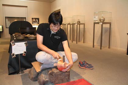 撮影コーナーで上がり盤に座って鎚起銅器職人のようにポーズをとって写真を撮れる