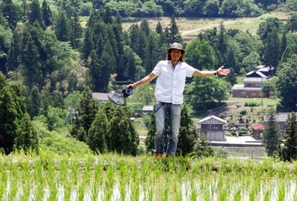一眼レフカメラで棚田の写真を撮る柳生さん