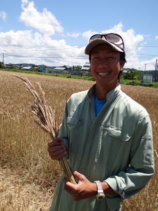 麦の穂を手に内山会長